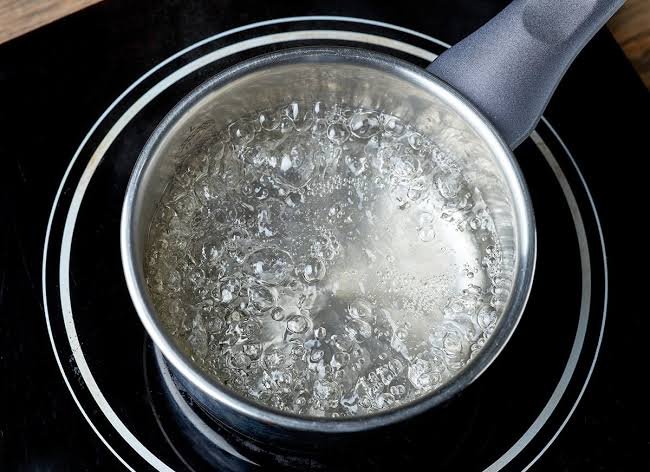 Water being boiled in a pot to make it safe to drink after flooding