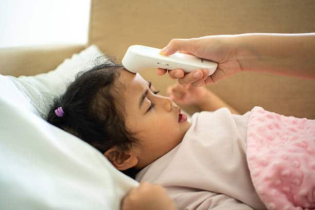 Mother caring for a child with fever at home