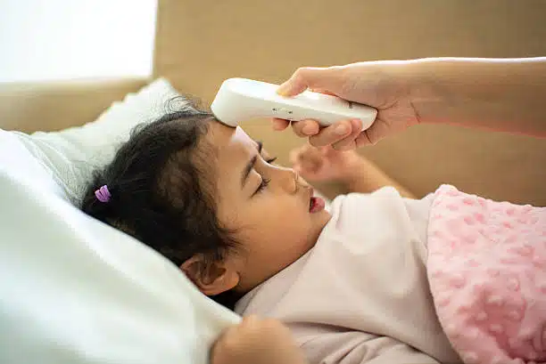 Mother caring for a child with fever at home